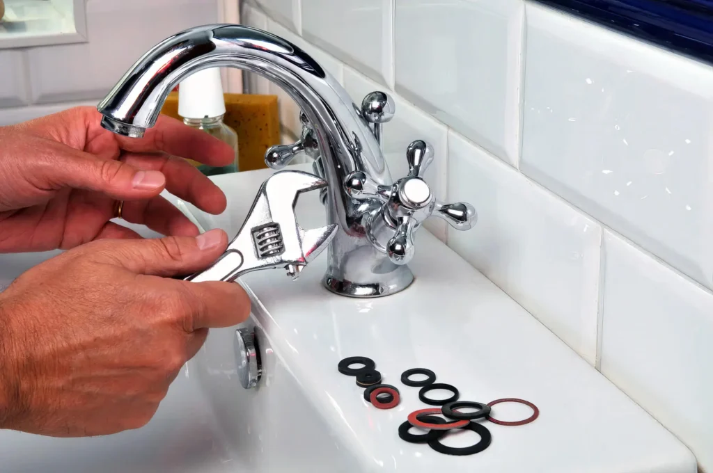 Plumber performing maintenance on a bathroom faucet in Corvallis