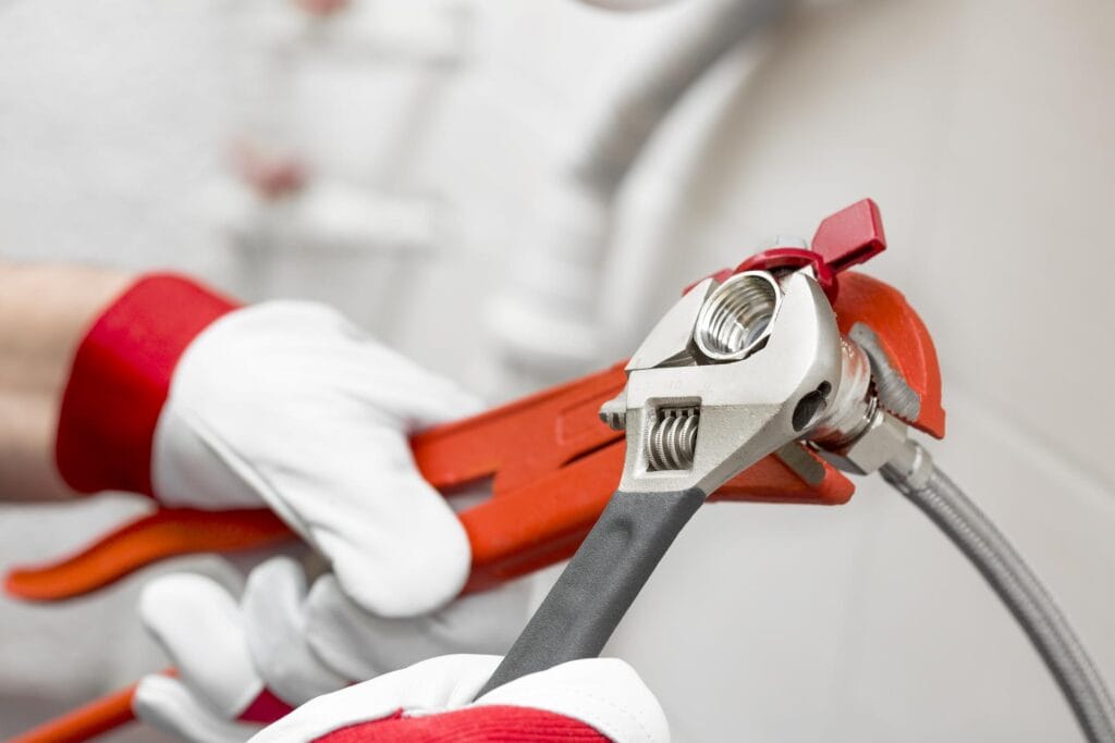 Plumber holding pipe wrenches for an emergency repair in Corvallis