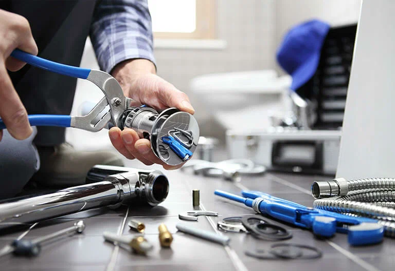 Technician repairing a plumbing fixture with professional tools in Corvallis