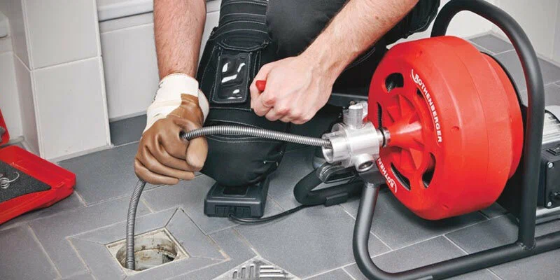 Plumber using a drain-cleaning machine in Corvallis