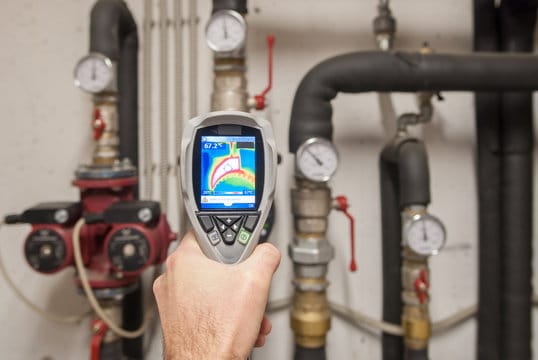 Plumber using a thermal imaging camera to inspect pipes in Corvallis
