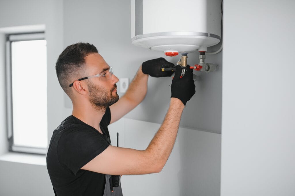 Technician performing water heater maintenance in Corvallis
